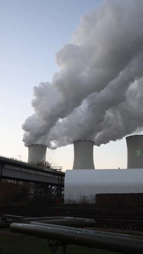 Vertical screen large cooling towers releasing thick white steam into the Stock Footage 321650781