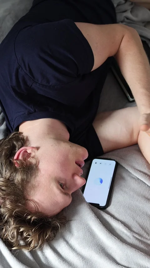 Vertical screen learning with artificial intelligence man lies on bed beside sma Stock Footage 314979551