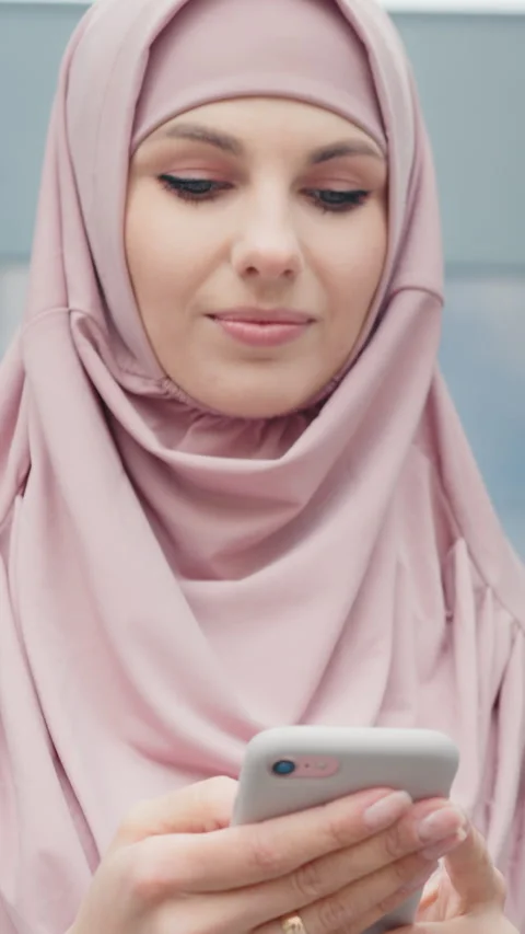 Vertical Screen: Low angle view of beautiful muslim woman standing near modern Stock Footage 272754470