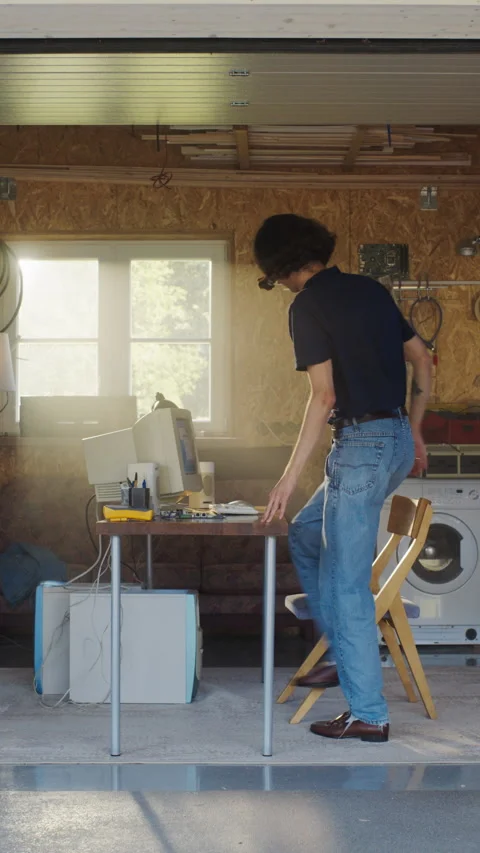 Vertical Screen Male Programmer Using Computer In Garage Stock Footage 256000764
