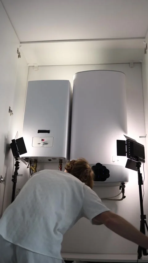 Vertical screen man checking home water heating and boiler system inside small t Stock Footage 318867764