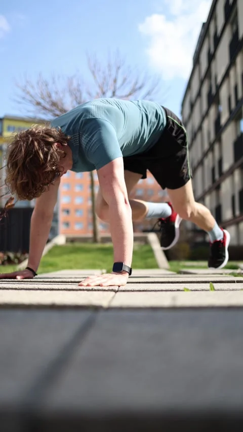 Vertical screen. A man doing a quick morning workout near the entrance of an apa Stock Footage 305999101