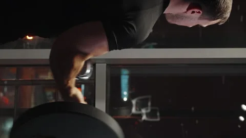 Vertical Screen: Man exercising with barbell near window Stock Footage 243501139