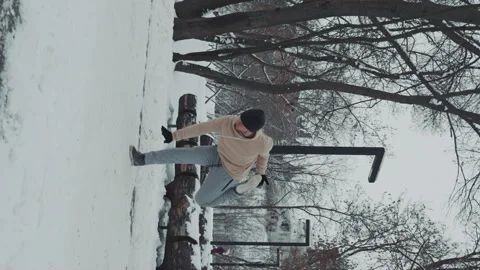 Vertical Screen: Man exercising in snow covered park Stock Footage 243415326