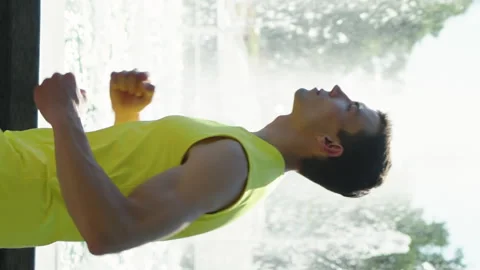 Vertical Screen: Man jogging against fountain in park Stock Footage 249004412