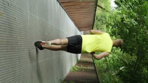 Vertical Screen: Man jogging in slow motion on bridge Stock Footage 247523017
