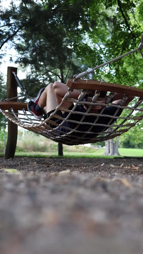 Vertical screen man lies back in hammock under green trees enjoying calm rest af Stock Footage 315413793