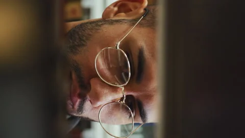 Vertical Screen: Man looking for book on shelves in library Stock Footage 220568794