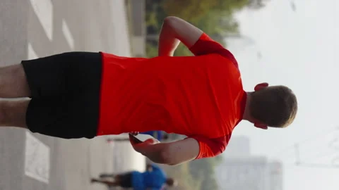 Vertical Screen: Man running marathon with smartphone in hand Stock Footage 223014363