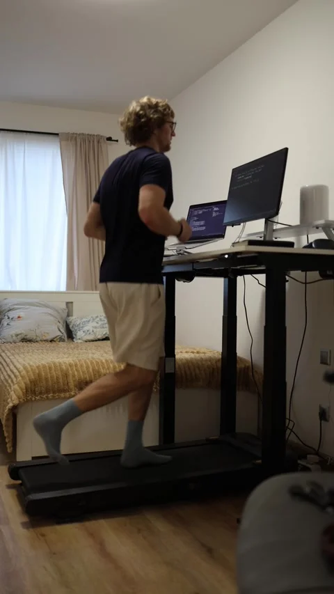 Vertical screen man runs on treadmill while lowering electric standing desk comb Video stock 346881469