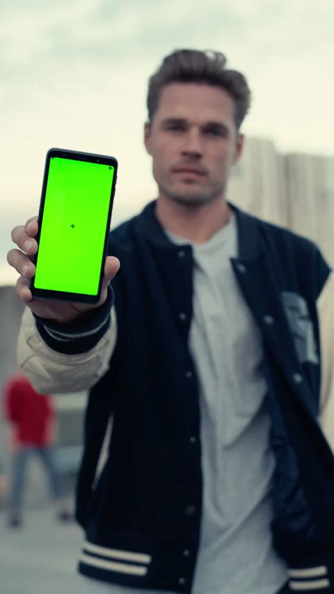 Vertical Screen Man Showing Smartphone with Green Screen Vidéo 229851298