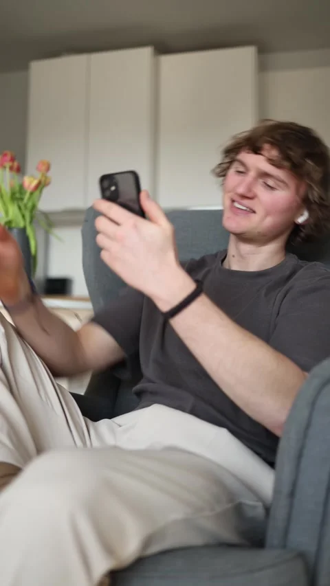 Vertical screen: The man smiles and takes a selfie, showcasing warm and happy mo Video stock 302633104