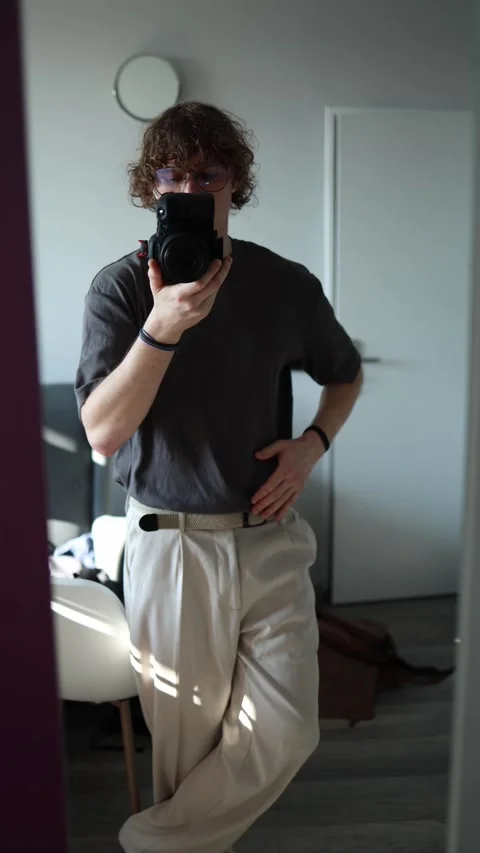 Vertical screen: A man takes a mirror selfie with a professional camera, wearing Stock Footage 301240559