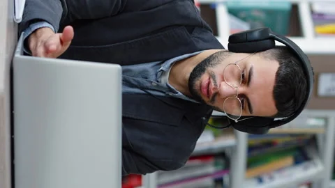 Vertical Screen: Man using headphones and laptop for video call Stock Footage 228654007