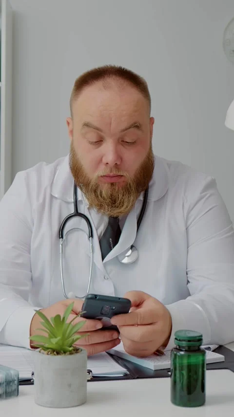 Vertical Screen medical worker talking smartphone and writes phone number. Video stock 299994681