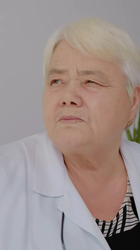 Vertical Screen Medicare assistant taking of glasses thinking of patient Stock Footage 299992211