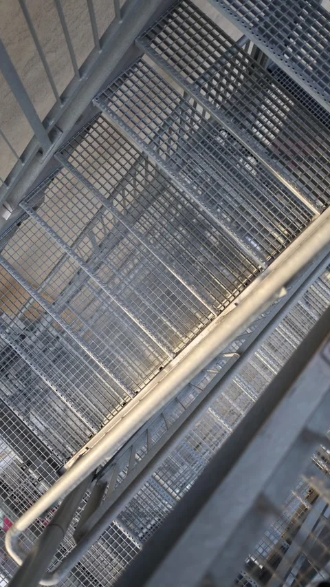 Vertical screen metal fire escape stairwell from above abstract lines urban geom Stock Footage 306007709
