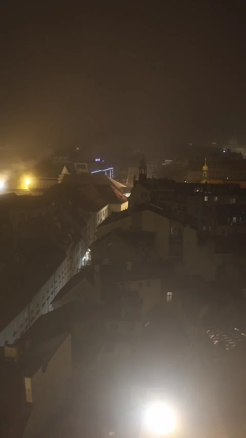 Vertical screen: A misty night view of a historic European city with dimly lit r Stock Footage 296543833