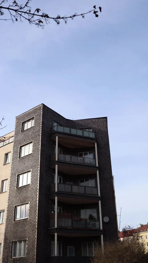 Vertical screen: Modern apartment building with unique dark tile facade and laye Stock Footage 304884258