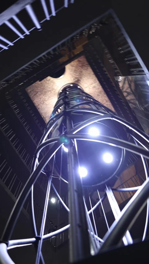 Vertical screen: A modern elevator ascending within a sleek spiraling structure, Video stock 296532686
