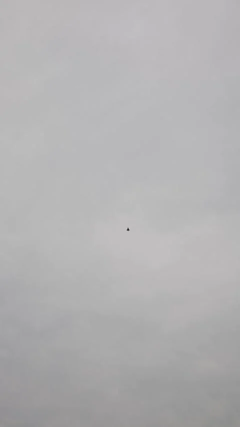 Vertical screen modern fighter jet climbs sharply against overcast sky creating  Stock Footage 311150150