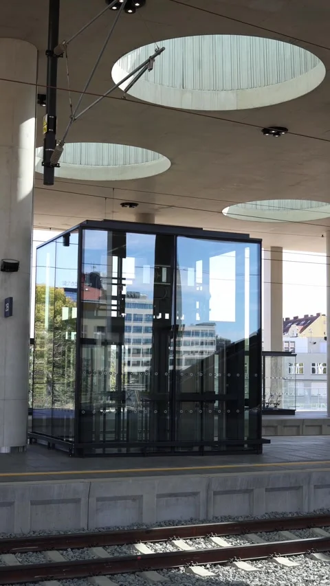 Vertical screen modern glass elevator on a railway station platform with reflect Stock Footage 317506433