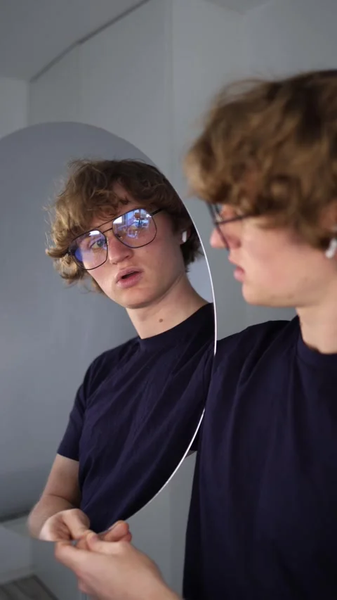 Vertical screen moment of surprise as the guy stares at his reflection with part Stock Footage 313268945
