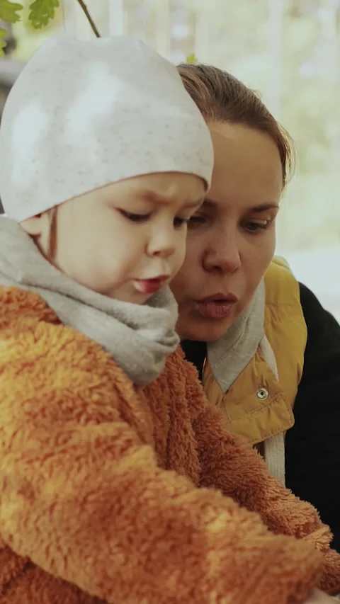 Vertical screen: A mother and her child are enjoying nature in a quiet autumn Stock-Footage 307681877