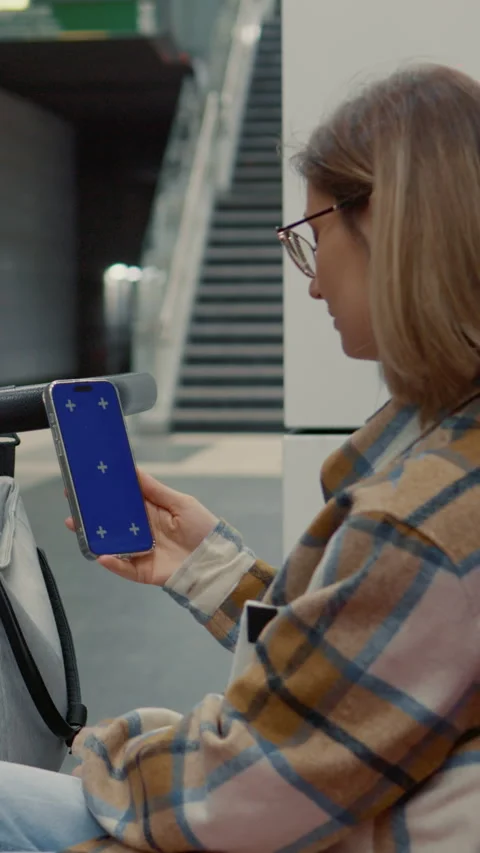 Vertical Screen Mother using smartphone while waiting for subway with her baby Stock Footage 303565775
