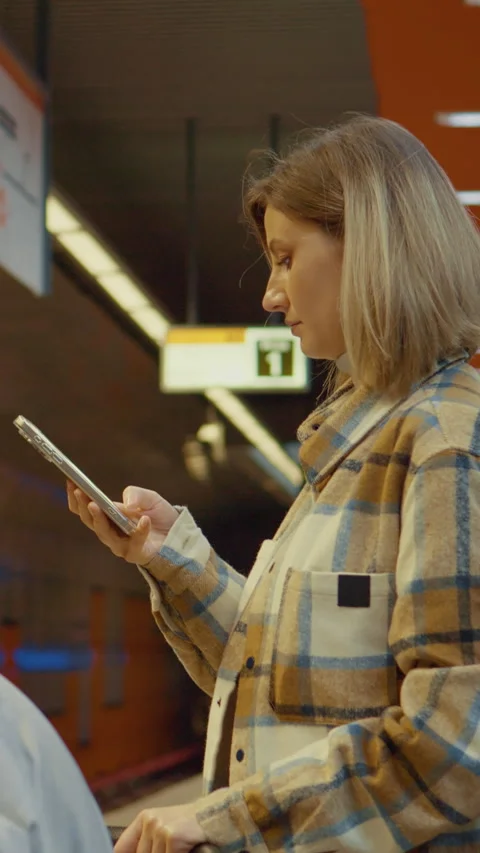 Vertical Screen Mother using smartphone while waiting for subway with baby Stock Footage 303566452