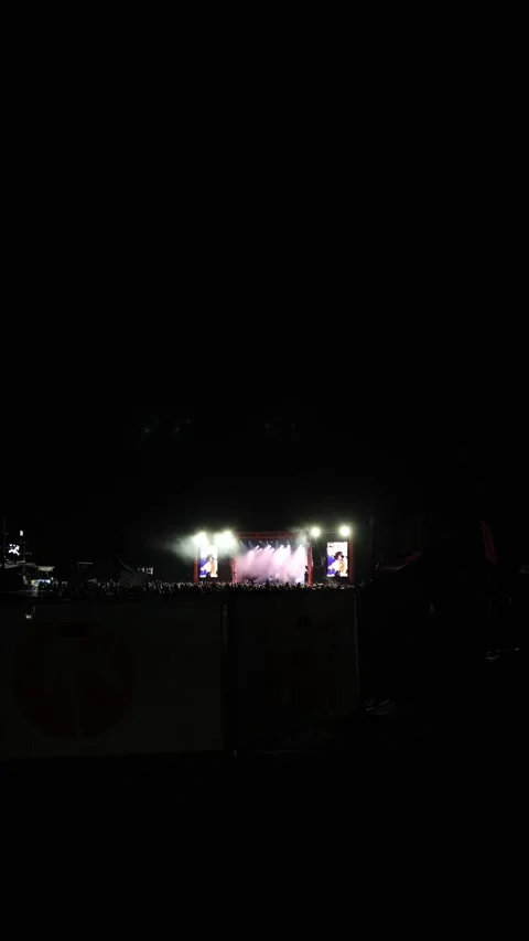 Vertical screen night concert with a large stage lit by bright spotlights colorf Stock Footage 316700061