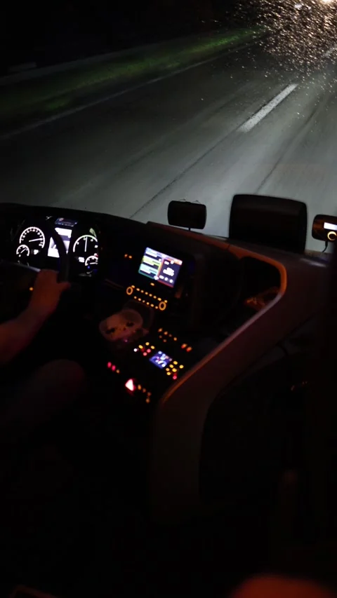 Vertical screen night drive illuminated dashboard glowing controls rainy windshi Stock Footage 310471219