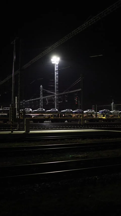Vertical screen night railway yard with cars loaded on freight wagons illuminate Stock Footage 319242289