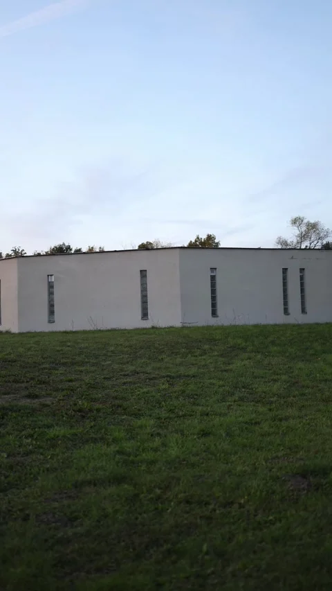 Vertical screen old concrete bunker with narrow windows surrounded by green gras Stock Footage 319832772