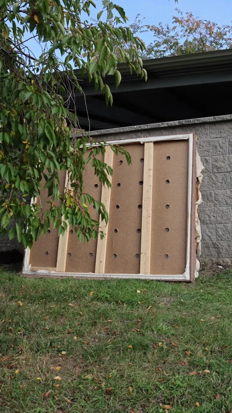 Vertical screen old damaged bed frame with torn upholstery and exposed wooden be Video stock 319841705