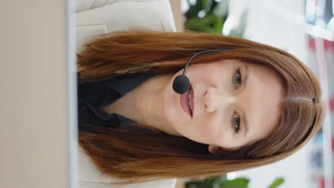 Vertical Screen: Operator of call center using headset and talking to customer Stock Footage 223489344