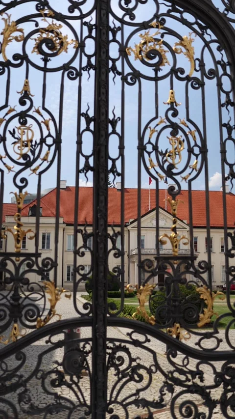 Vertical screen Ornate black gates with golden accents reveal a grand historic b Stock Footage 312696971