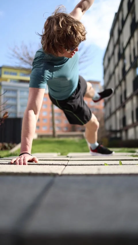 Vertical screen. Outdoor workout showcasing a man holding a side plank position  Video stock 305999066