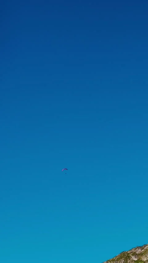 Vertical Screen Parachutist in the distance over the mountain peak. Stock Footage 299989028