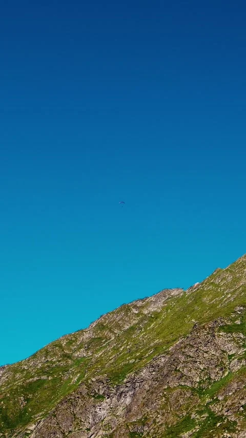 Vertical Screen Parachutist in the distance over the mountain peak. Stock Footage 299989077