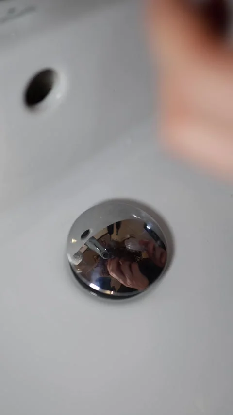 Vertical screen person combs their hair in front of sink reflection in chrome dr Video stock 309329940