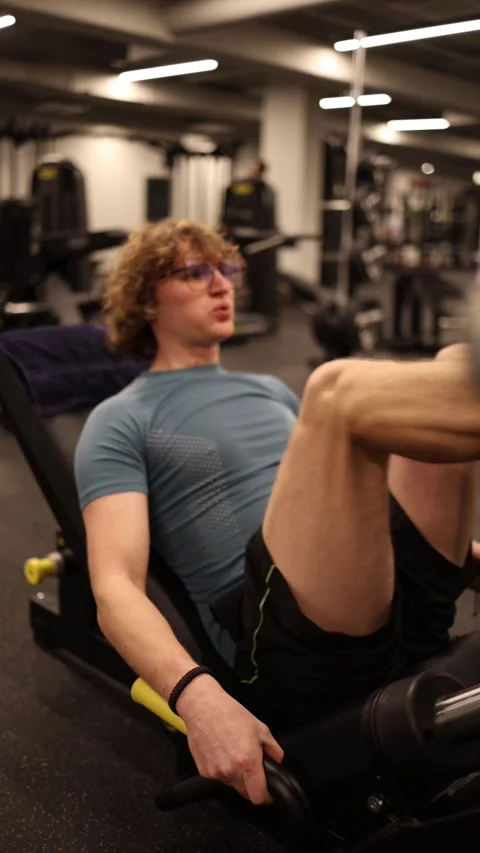 Vertical screen: The person is doing leg exercises at the gym, showing dedicatio Video stock 301676806