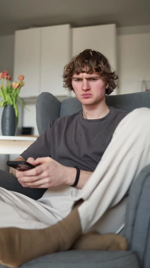 Vertical screen: The person looks frustrated and confused, intensely focusing on Stock Footage 302632897