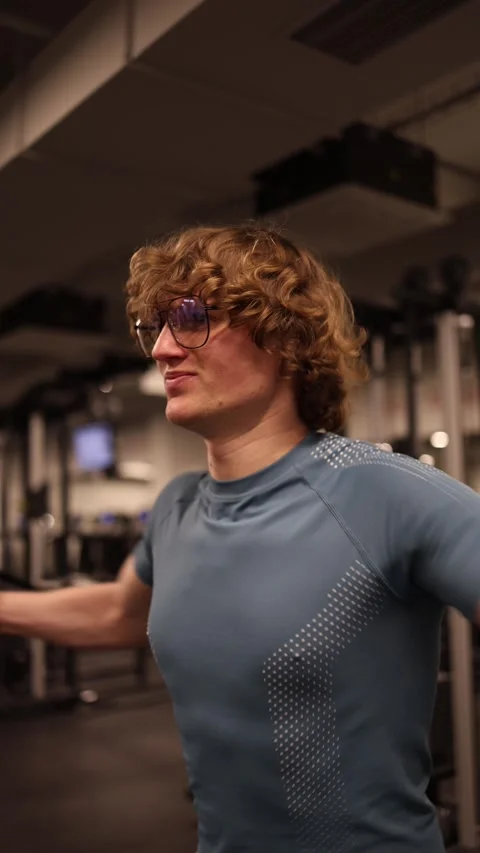 Vertical screen: A person is performing a cable chest fly in the gym, targeting  Stock Footage 301677066