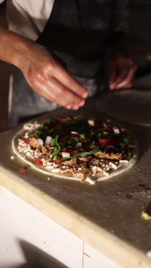 Vertical screen Raw pizza loaded with green peppers tomatoes onions and cheese o Stock Footage 310017977