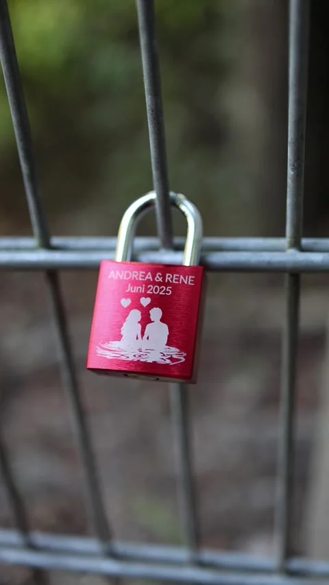 Vertical screen red love padlock attached to metal fence symbolizing eternal aff Vidéo 318778403
