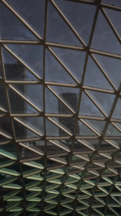 Vertical screen Reflections of city skyscrapers appear through the geometric gla Stock Footage 312696918
