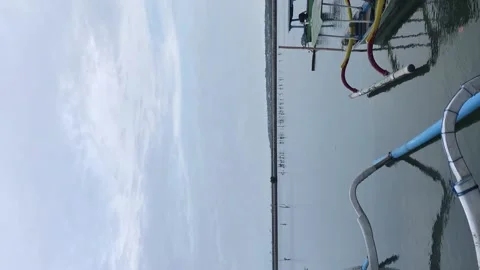 Vertical Screen: Relax on the beach. There is a fishing boat at anchor. Video stock 196985061