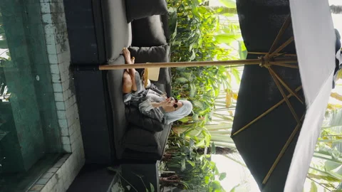 Vertical screen: relaxing on private terrace with pool drinking glass of wine Video stock 238534160