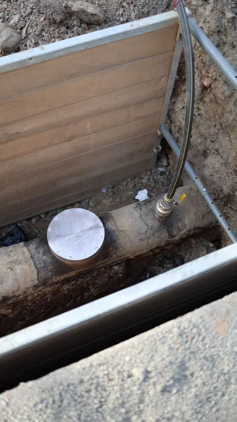 Vertical screen: Repaired underground pipeline segment with sealed access cap an Stock Footage 304884281